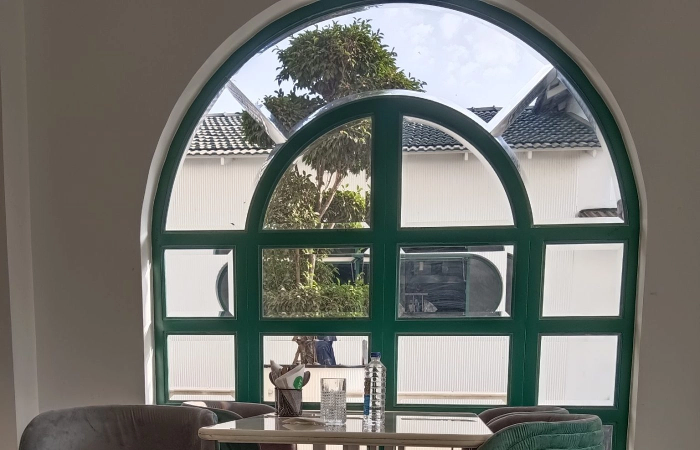 Table and chairs in front of a green arched window